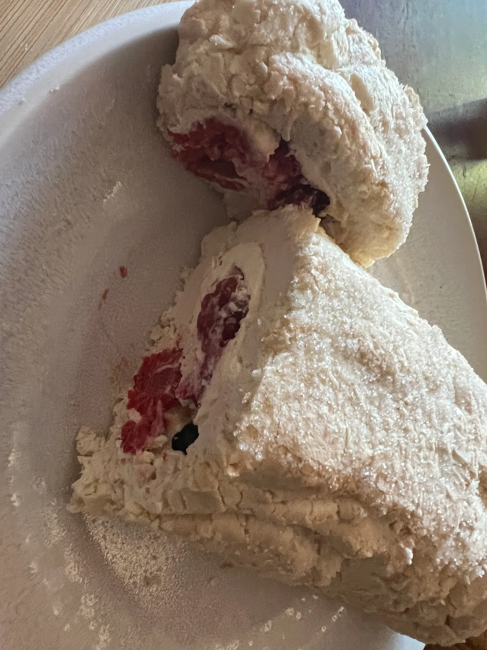 The meringue roulade cut open, showing the cream and berries.